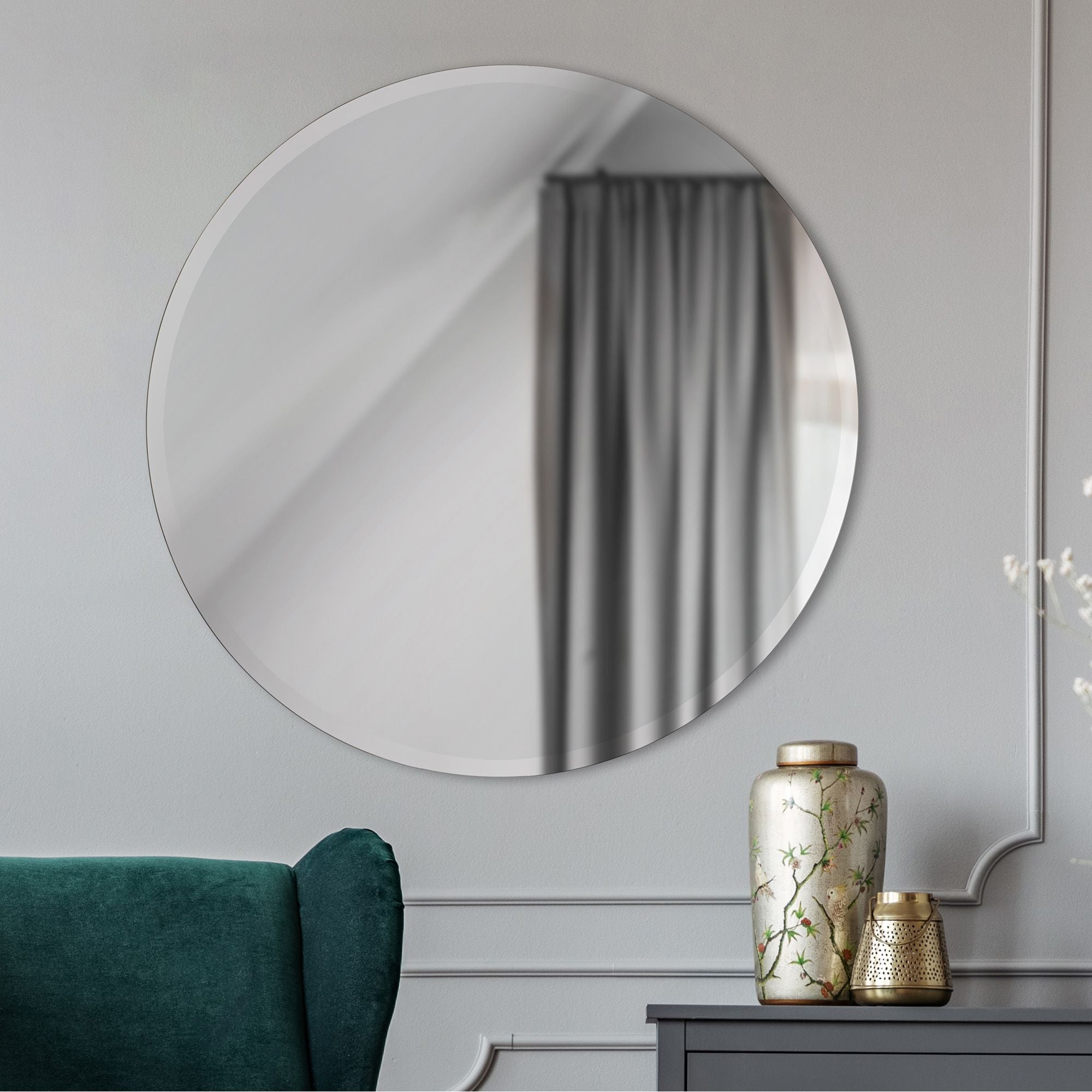 Kiko mirror displayed in a room, reflecting a gray curtain and decorative vases.