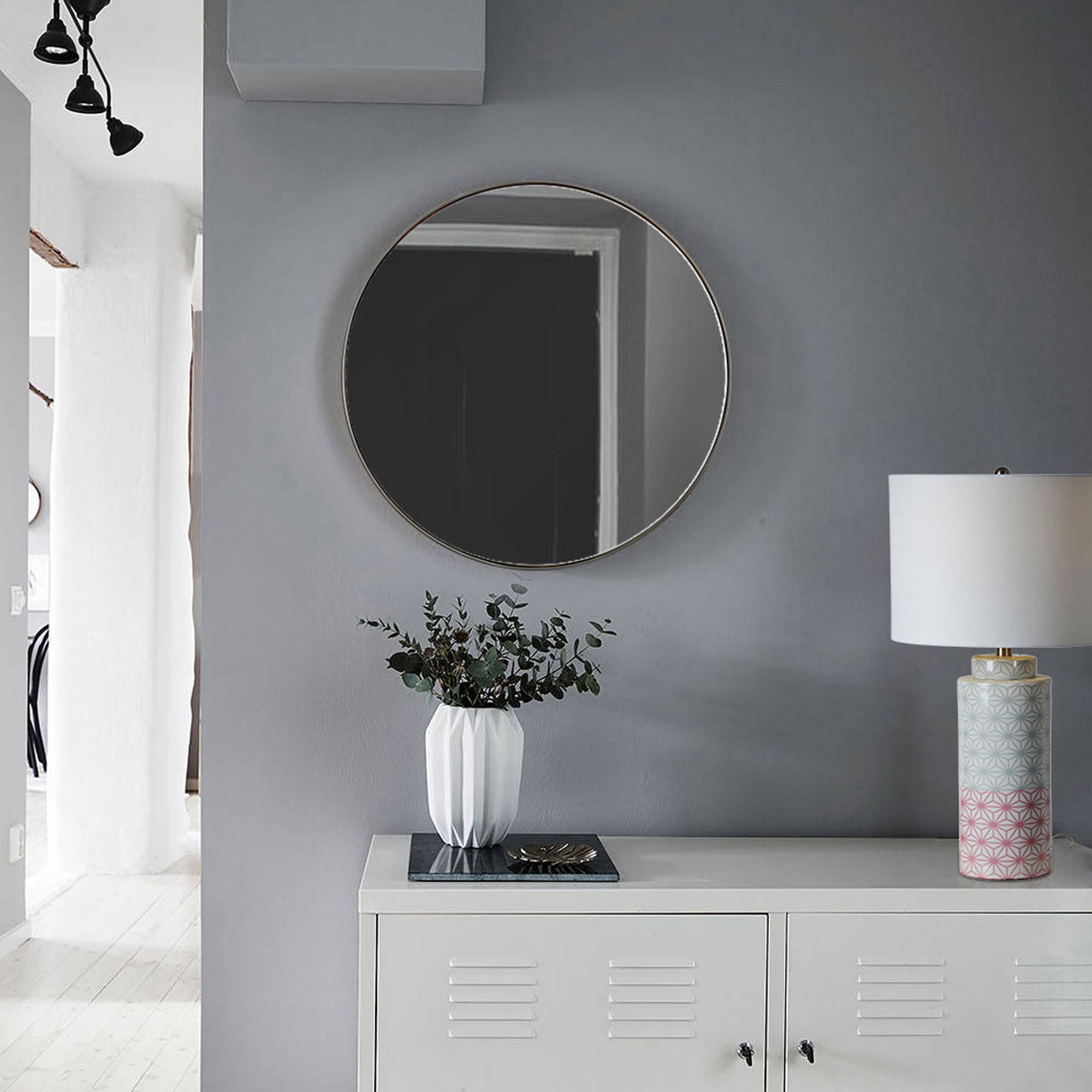 Lester mirror by Renwil, displayed on a gray wall above a console table with decor.