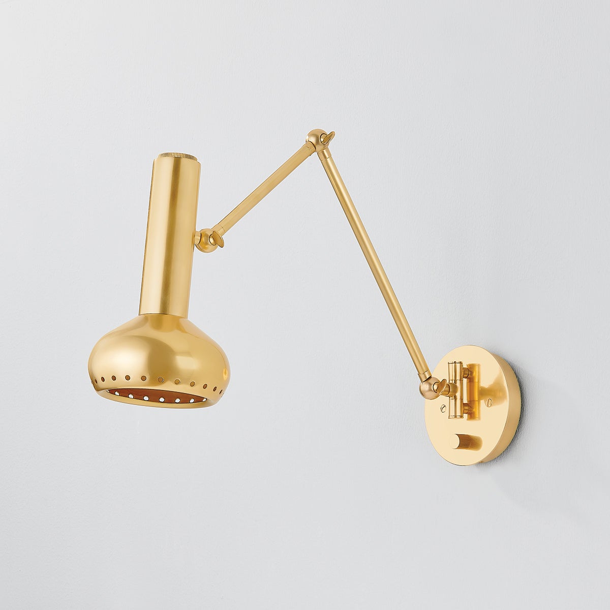 Close-up of the Roald Wall Sconce in aged brass showing the arm curve and shade silhouette.