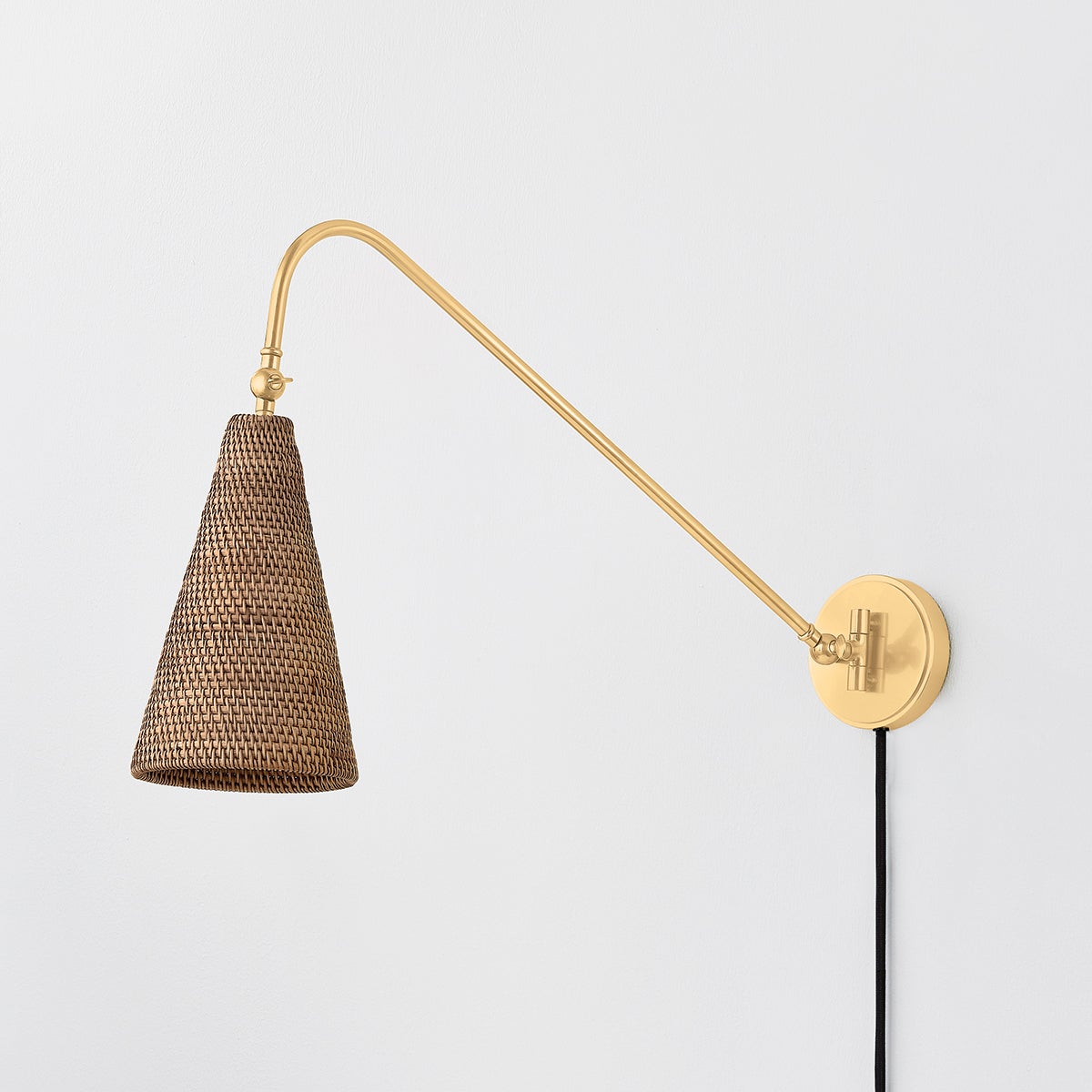 Averack Plug-In Sconce in aged brass shown from a second angle to highlight the arm profile and shade silhouette.