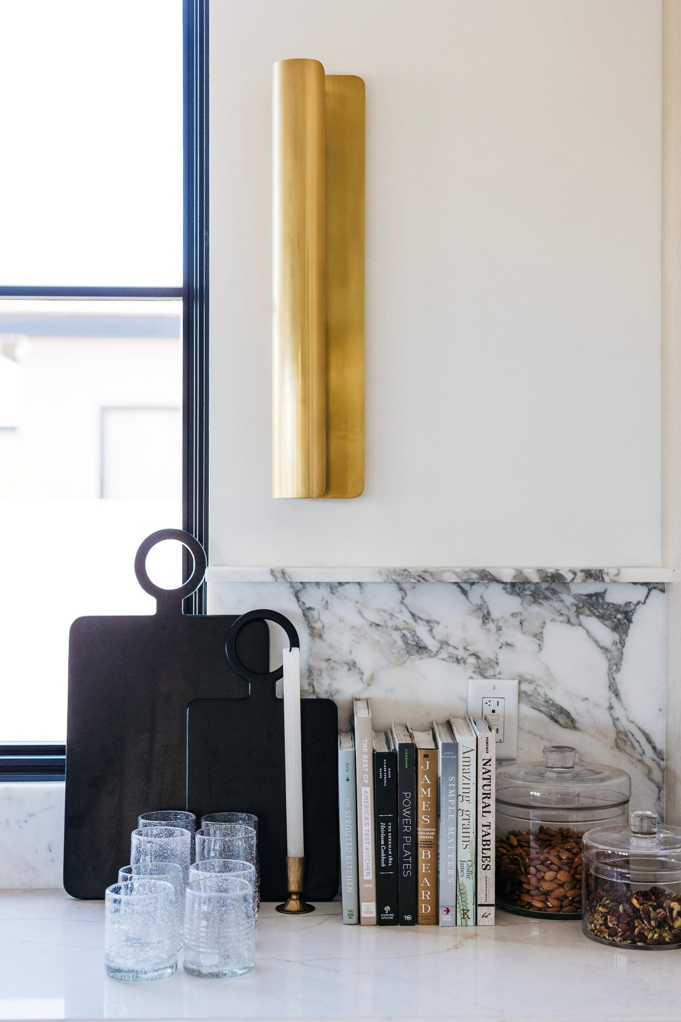 Accord Wall Sconce 5.5" x 25" in aged brass styled in a curated living room for warm, layered light at Laurie Yapp Home.
