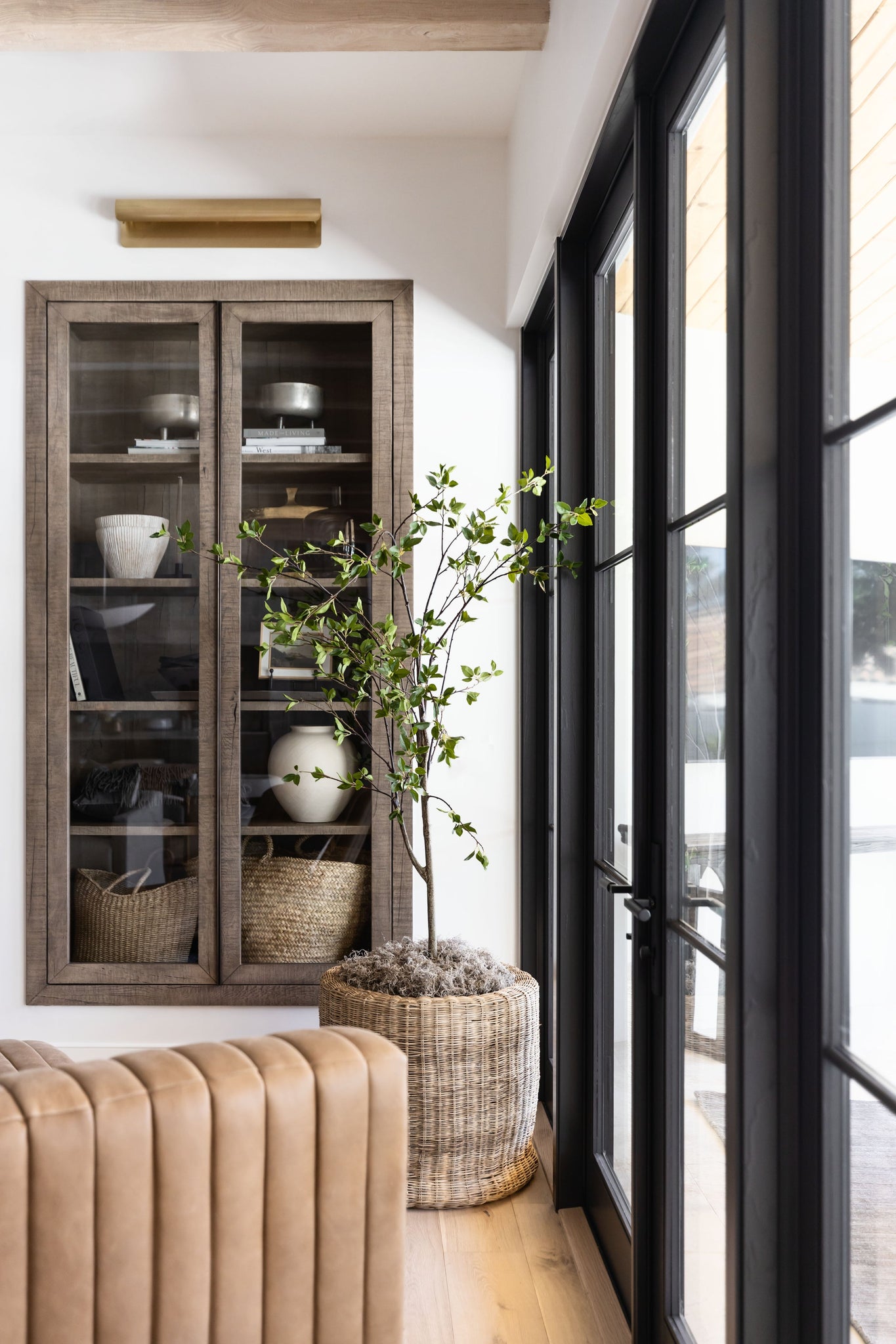 Accord Wall Sconce 5.5" x 25" in aged brass styled in a modern bathroom for warm, layered light at Laurie Yapp Home.
