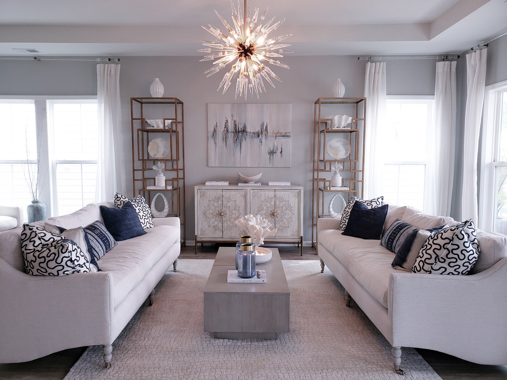 Sparta Chandelier 32" x 32" in aged brass styled in a formal living room for warm, layered light at Laurie Yapp Home.
