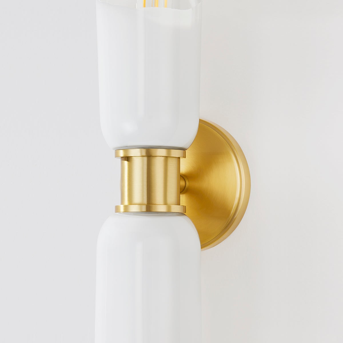 Wasson Wall Sconce in aged brass shown from the front to reveal the arm curve and shade silhouette.