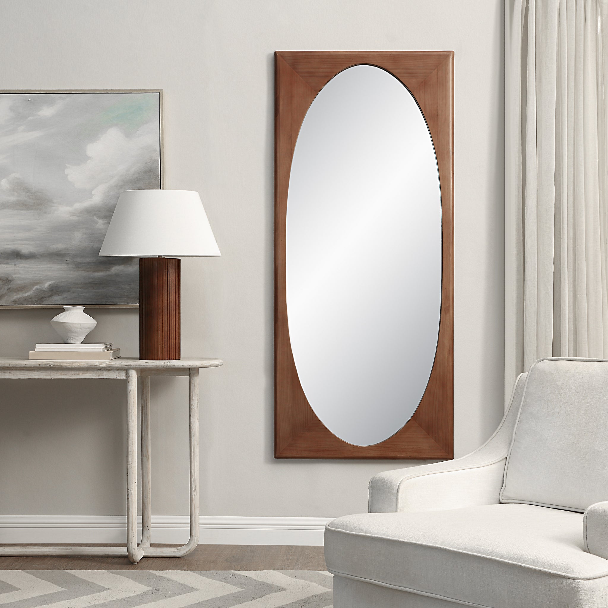 Sitia mirror by Renwil displayed in a room with a lamp and artwork.