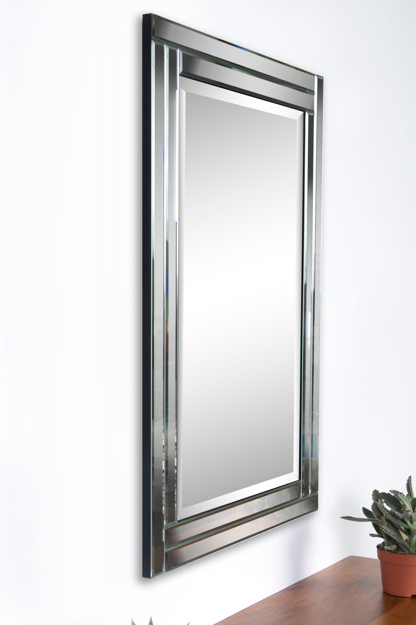 Ava Wall Mirror by Renwil displayed at an angle, featuring a chrome frame and modern design.
