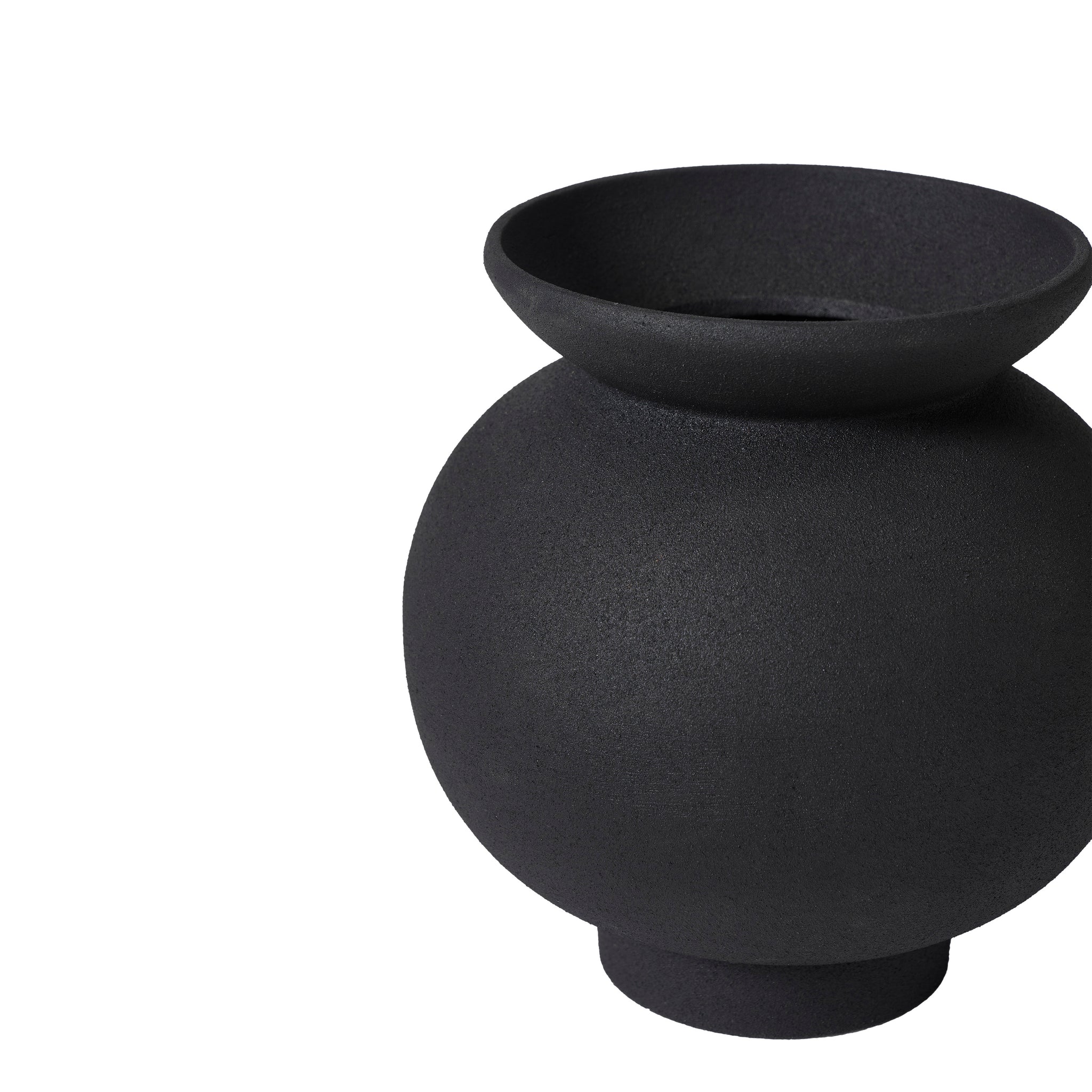 Cadiz vase by Renwil, black ceramic vase with a rounded shape, placed on a marble table with flowers.