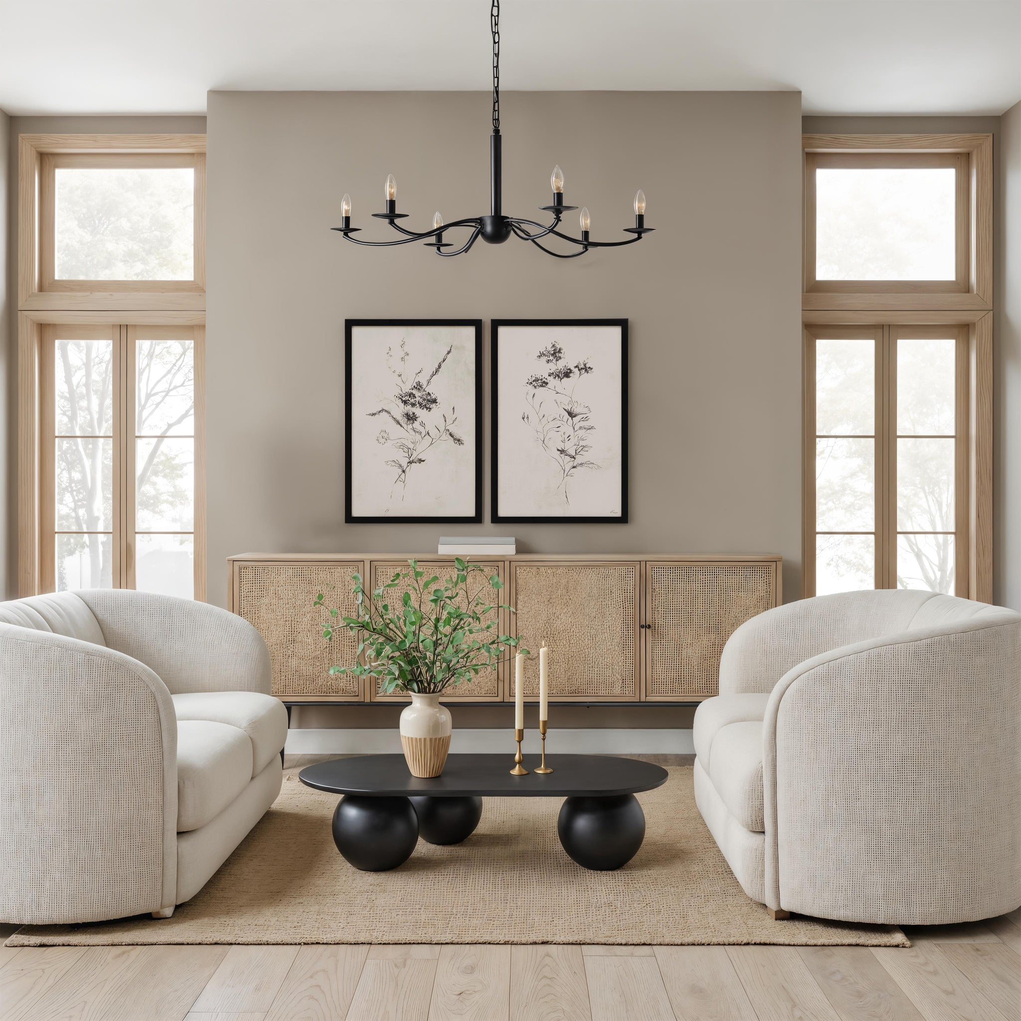 Adeline living room scene featuring two light beige sofas, black chandelier, and floral artwork.