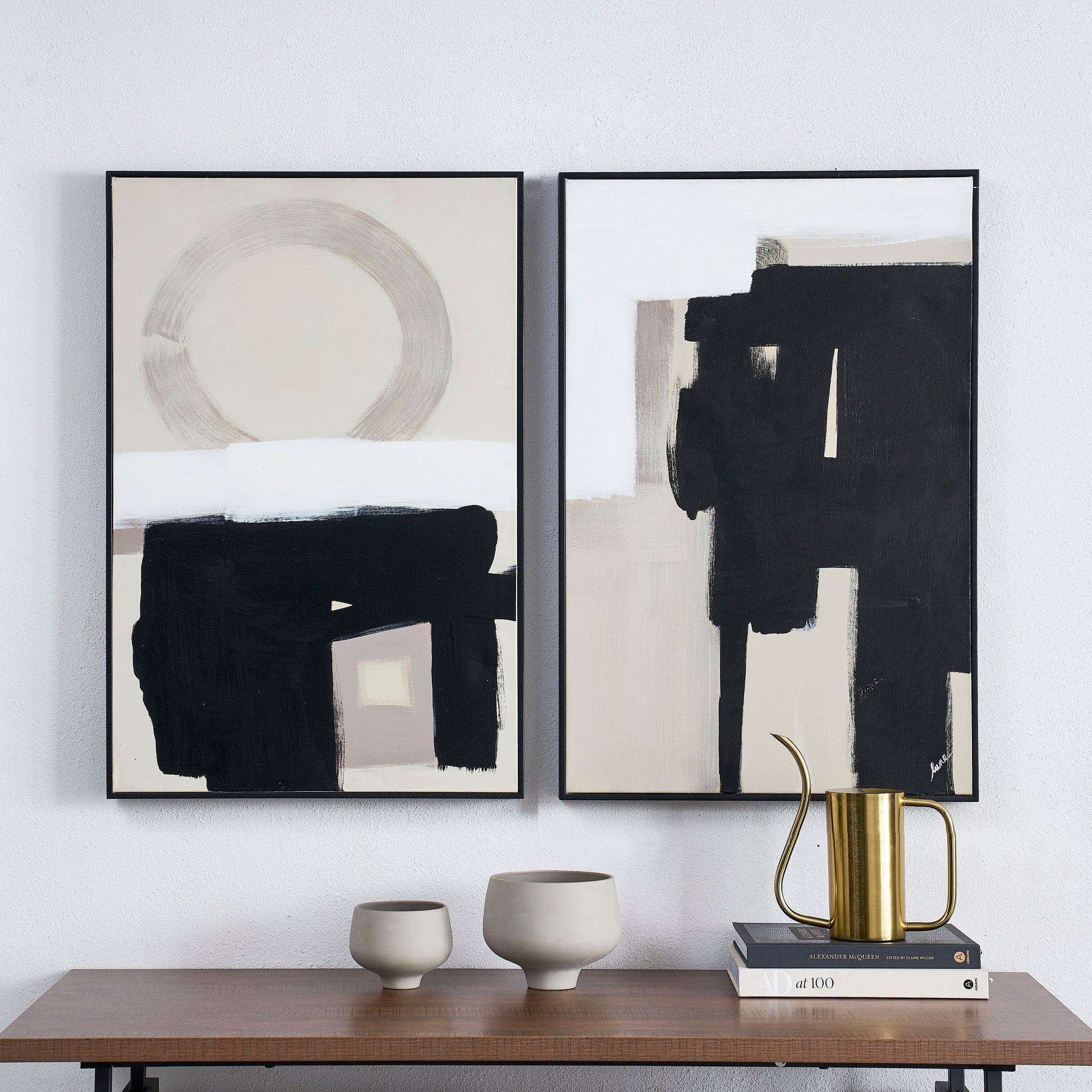 Telesto Canvas Art displayed on a wooden table alongside decorative vases and books.