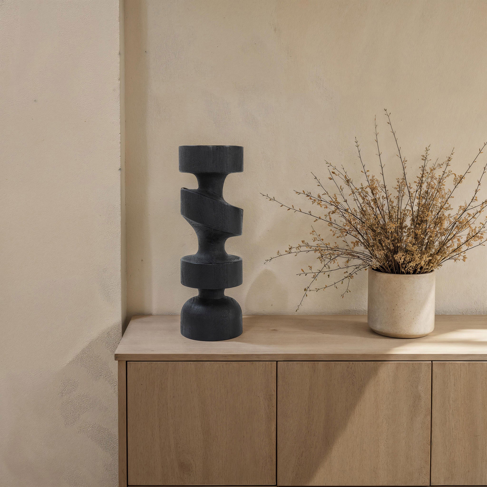 Beckton statue by Renwil on a wooden surface, paired with a vase and dried flowers.