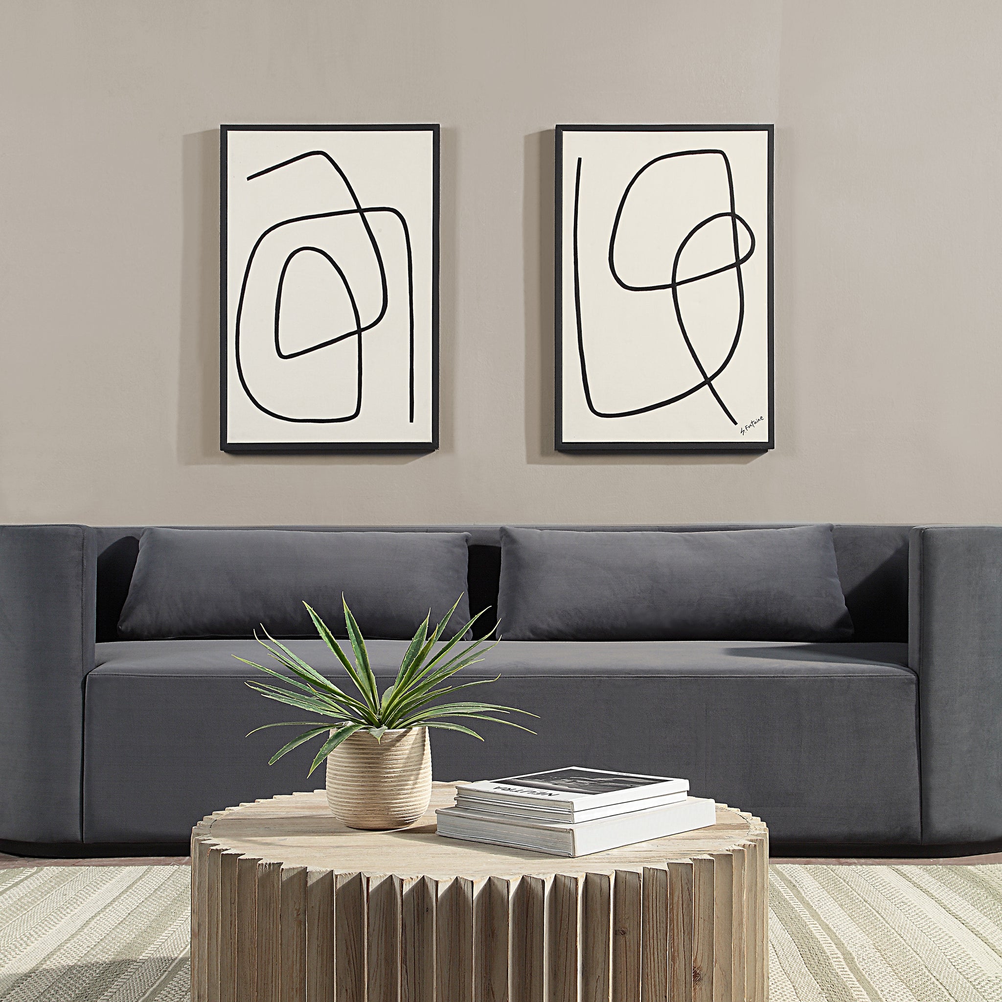 Moreau canvas art displayed in a living room above a gray sofa with a round wooden coffee table.
