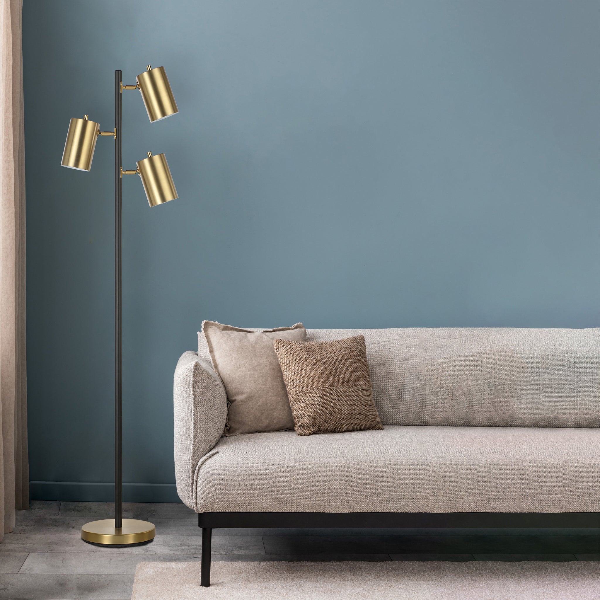 Mosaic floor lamp beside a light gray sofa with decorative pillows against a blue wall.