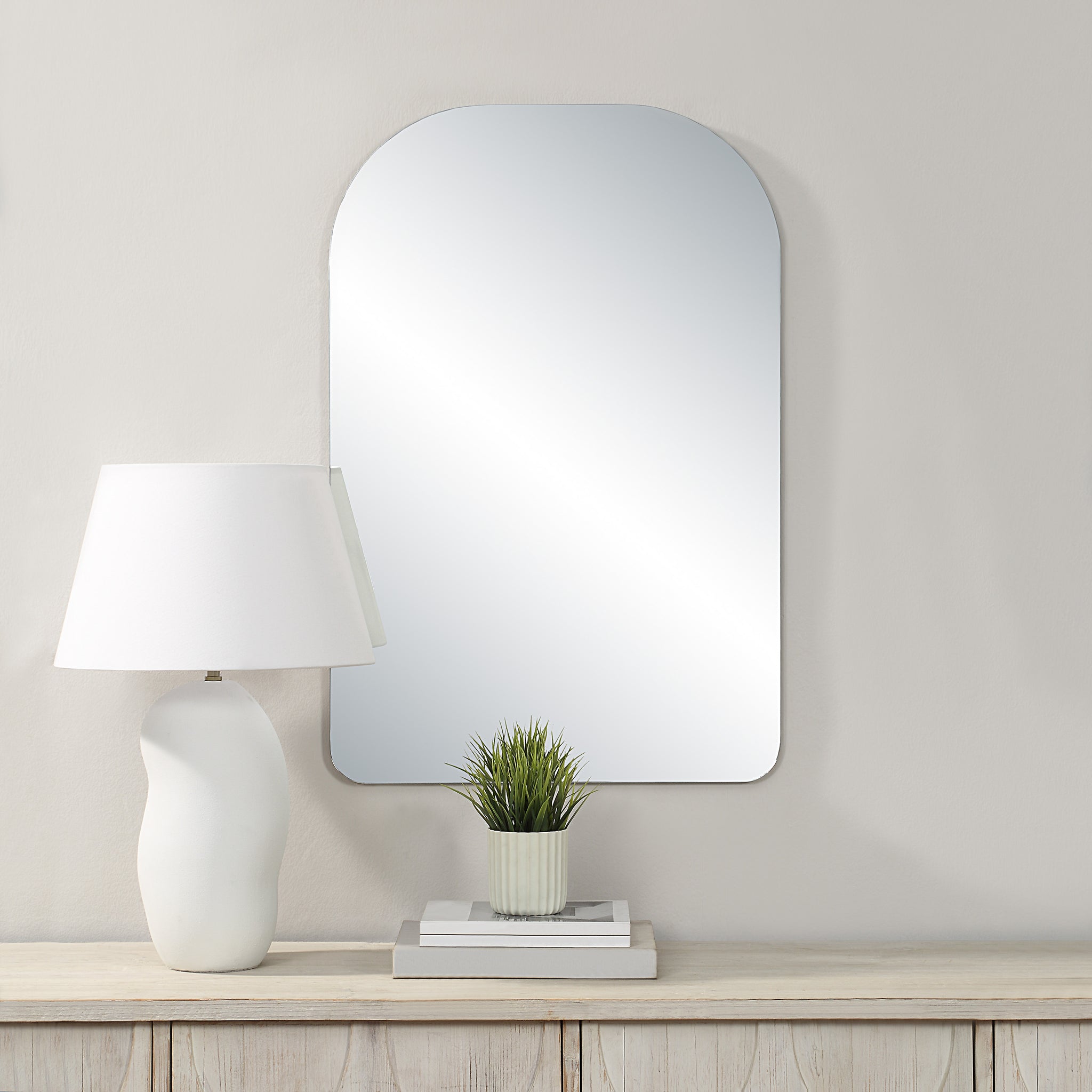 Chania mirror by Renwil displayed on wall with lamp and plant, modern decor