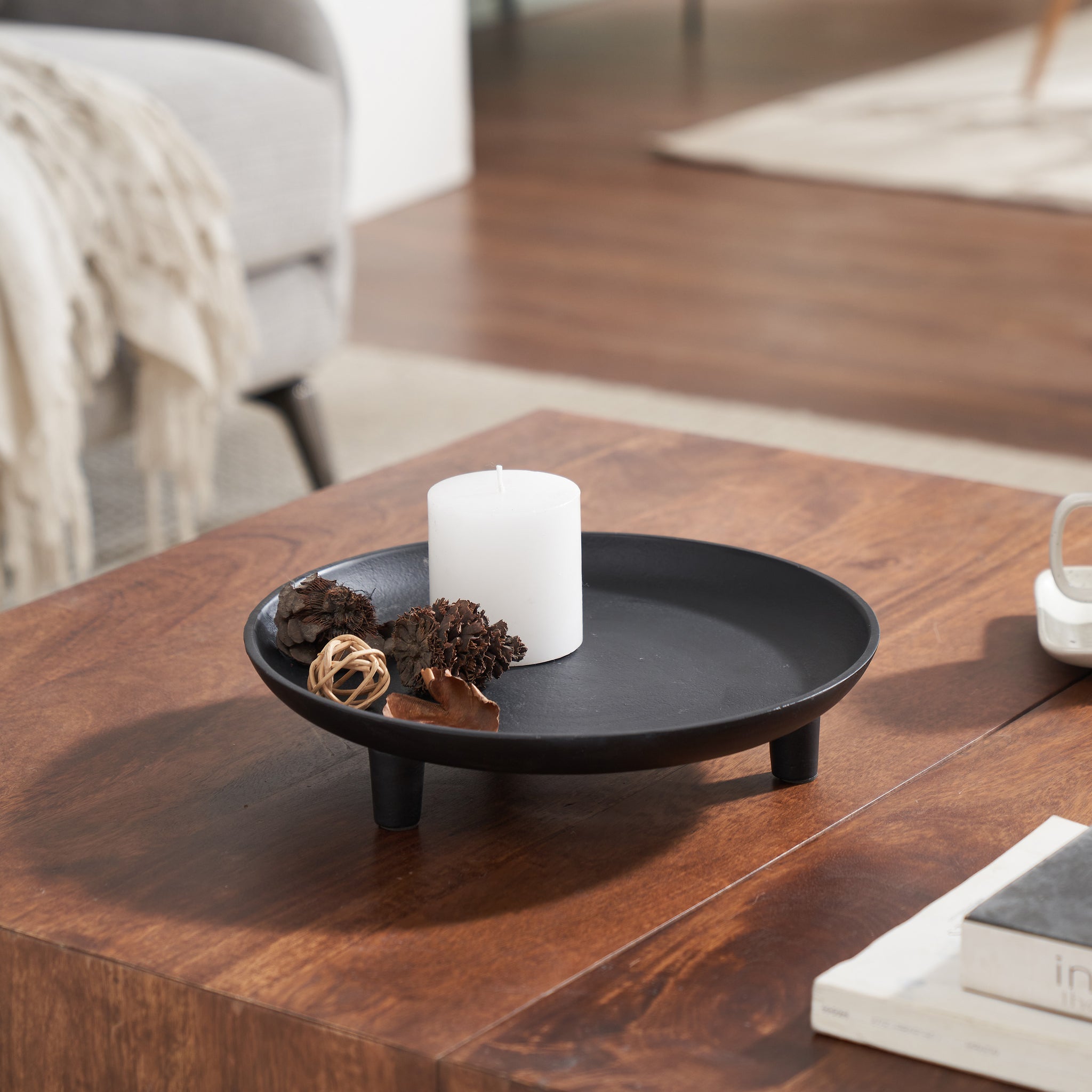 Elisa decorative bowl in black, styled with a candle and decorative items on a wooden table