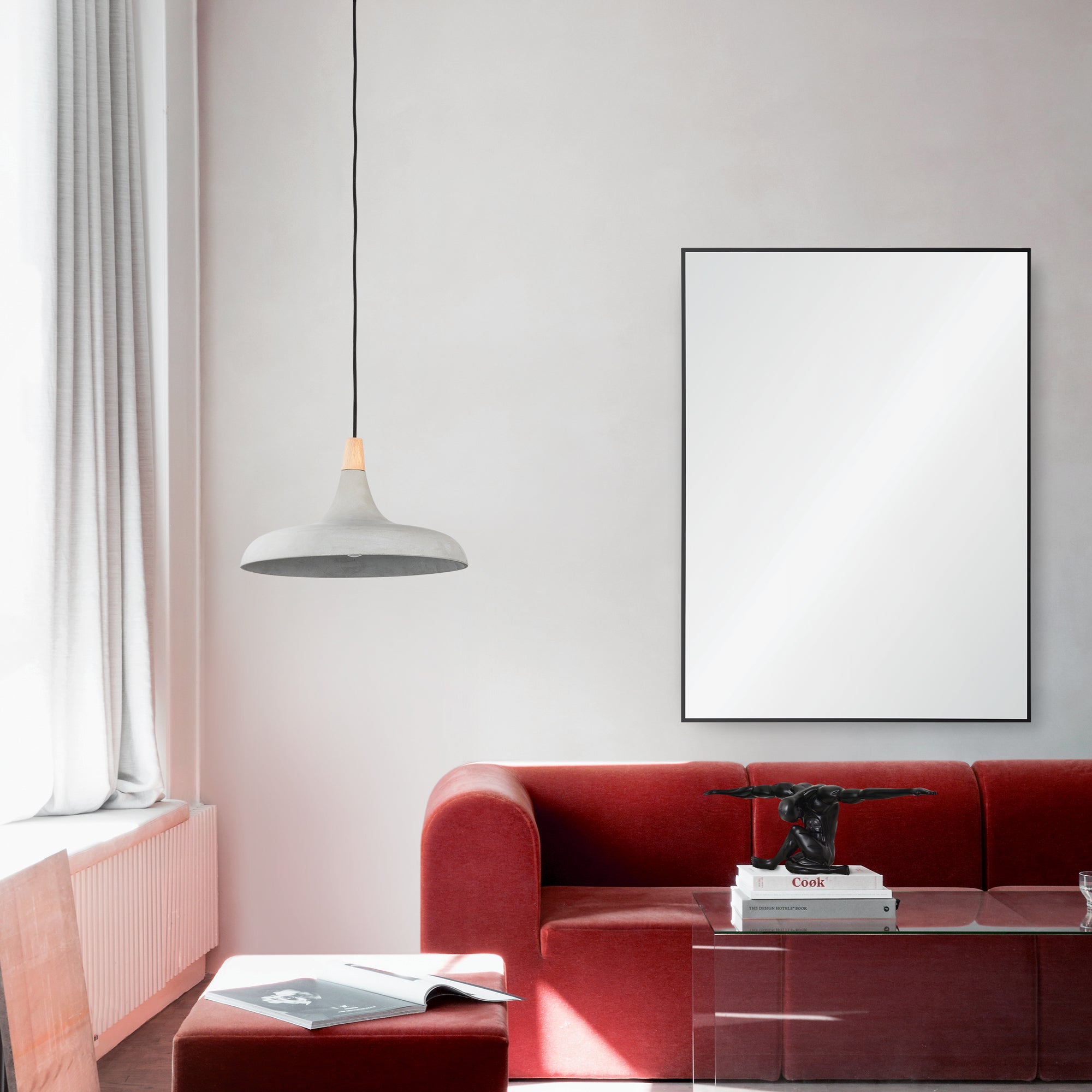 Raizel Wall Mirror displayed in a modern living room with red sofa and pendant light.