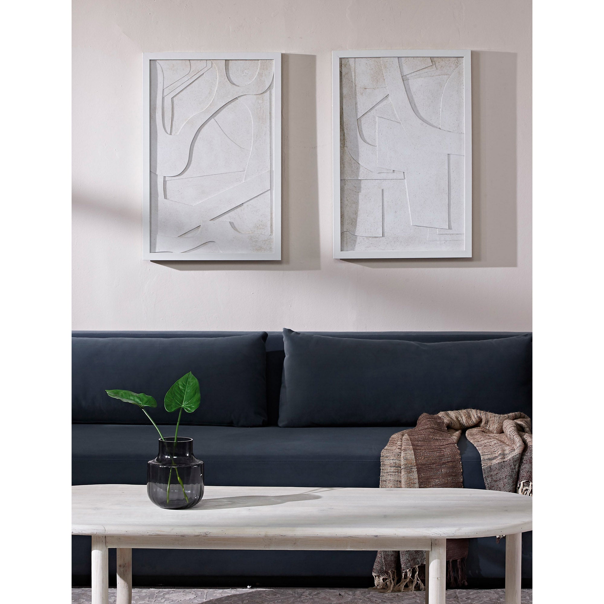 Pathfinder wall art displayed in a living room above a dark sofa with a coffee table and plant.