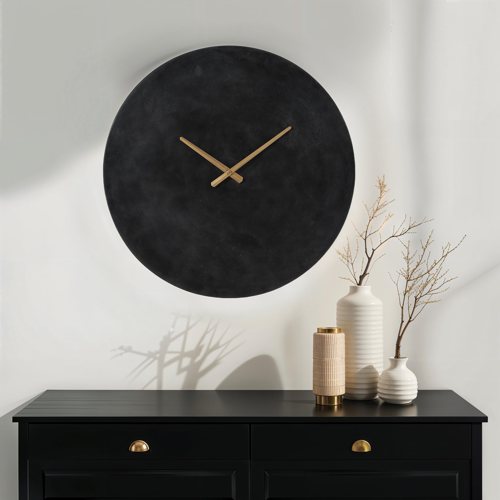Darnay Wall Clock displayed on a wall with vases and decor on a black dresser.