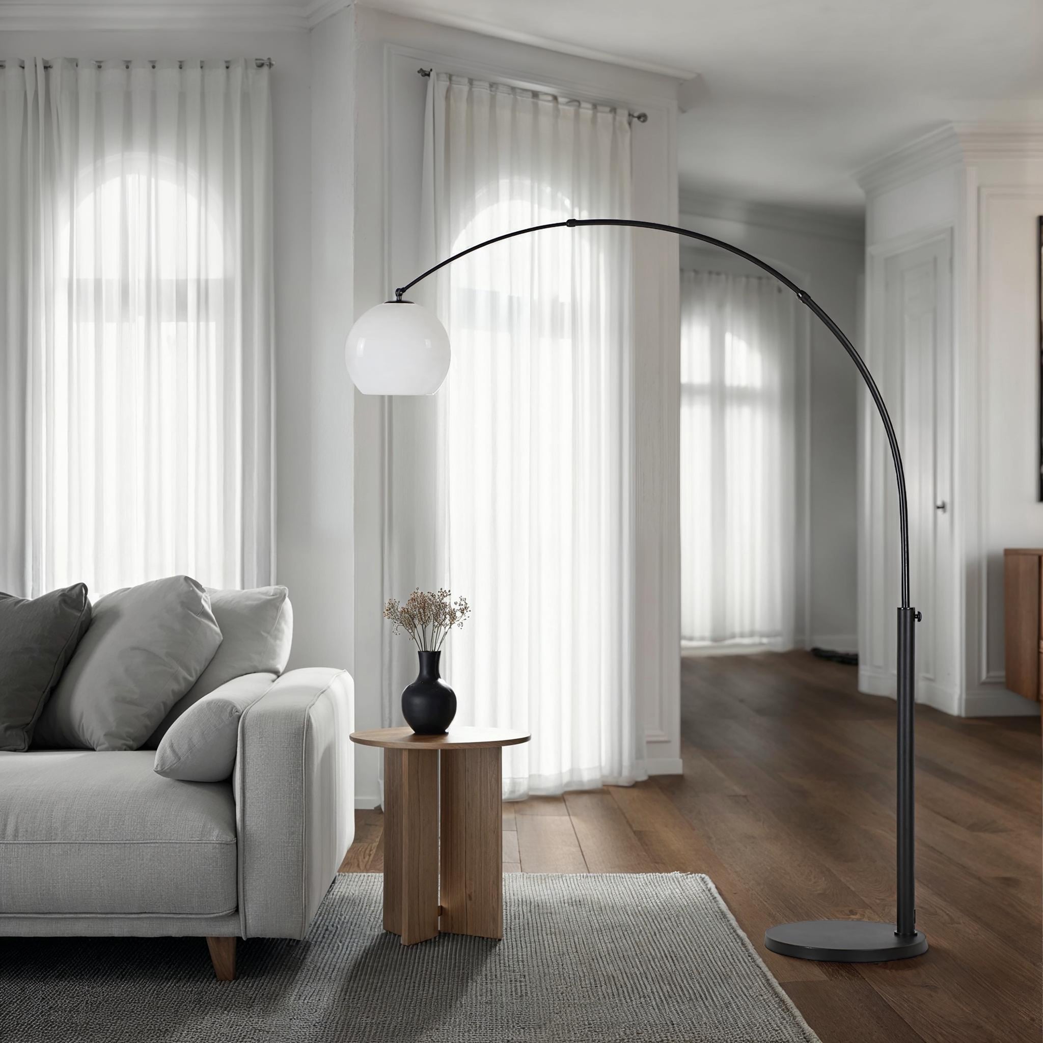 Pura Floor Lamp by Renwil in a living room setting, black metal with white globe above a sofa