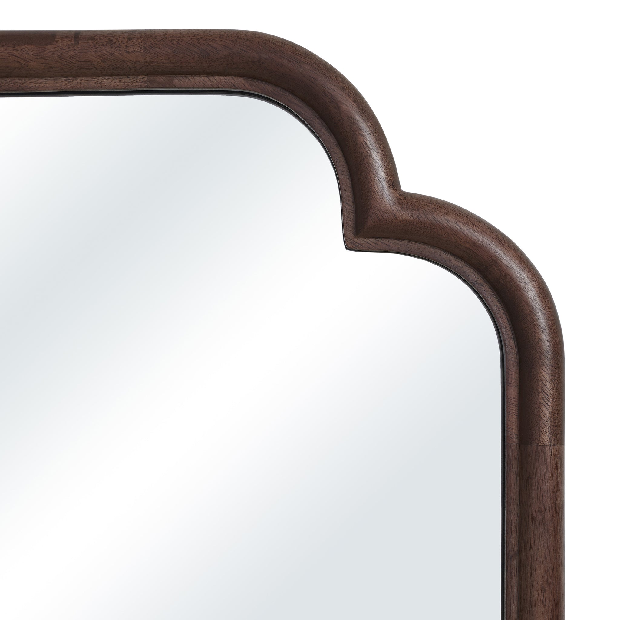 Close-up of Octavian mirror's brown wood frame with an arched top detail.