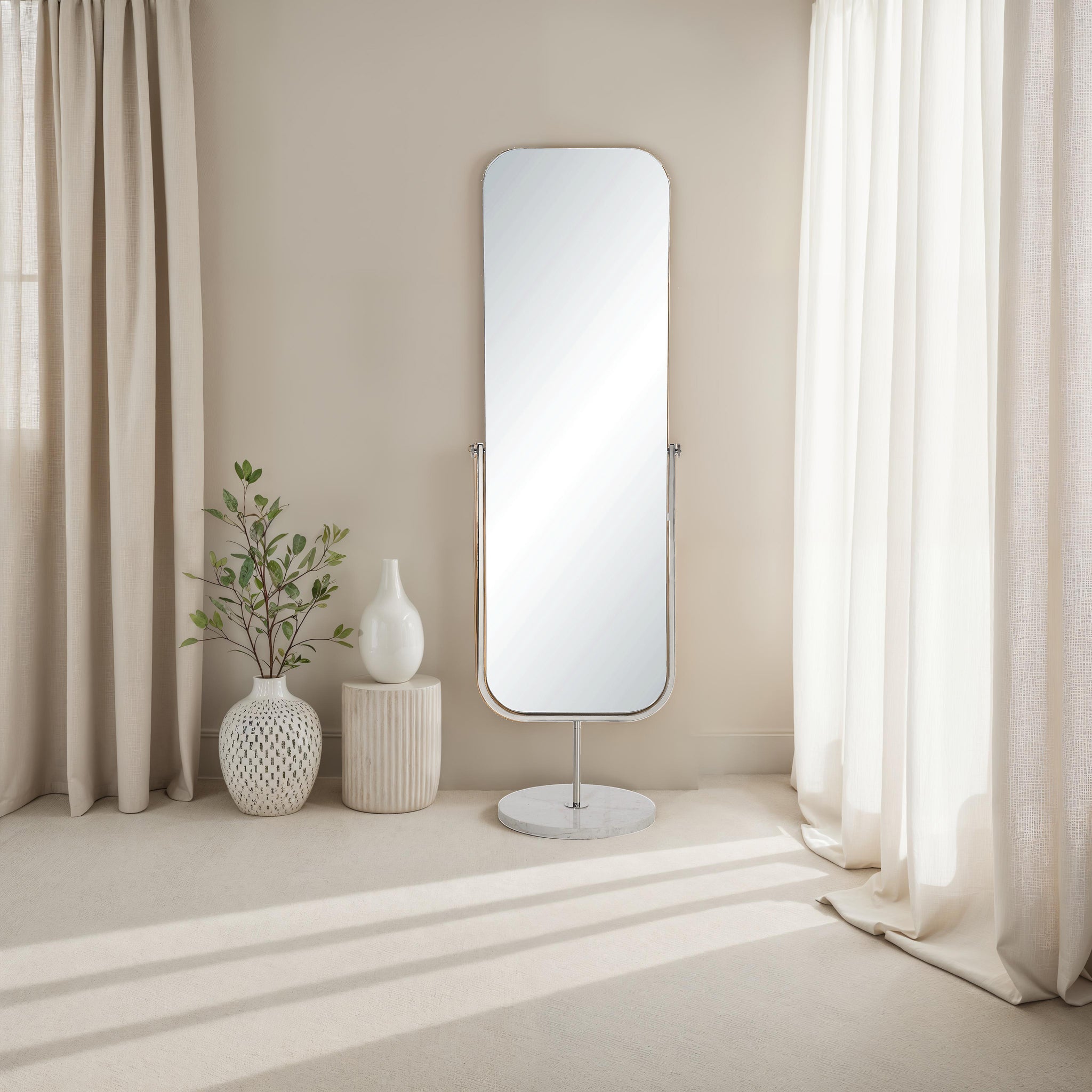 Mandra mirror by Renwil, tall rectangular design with a sleek silver frame, placed beside a plant and vase.