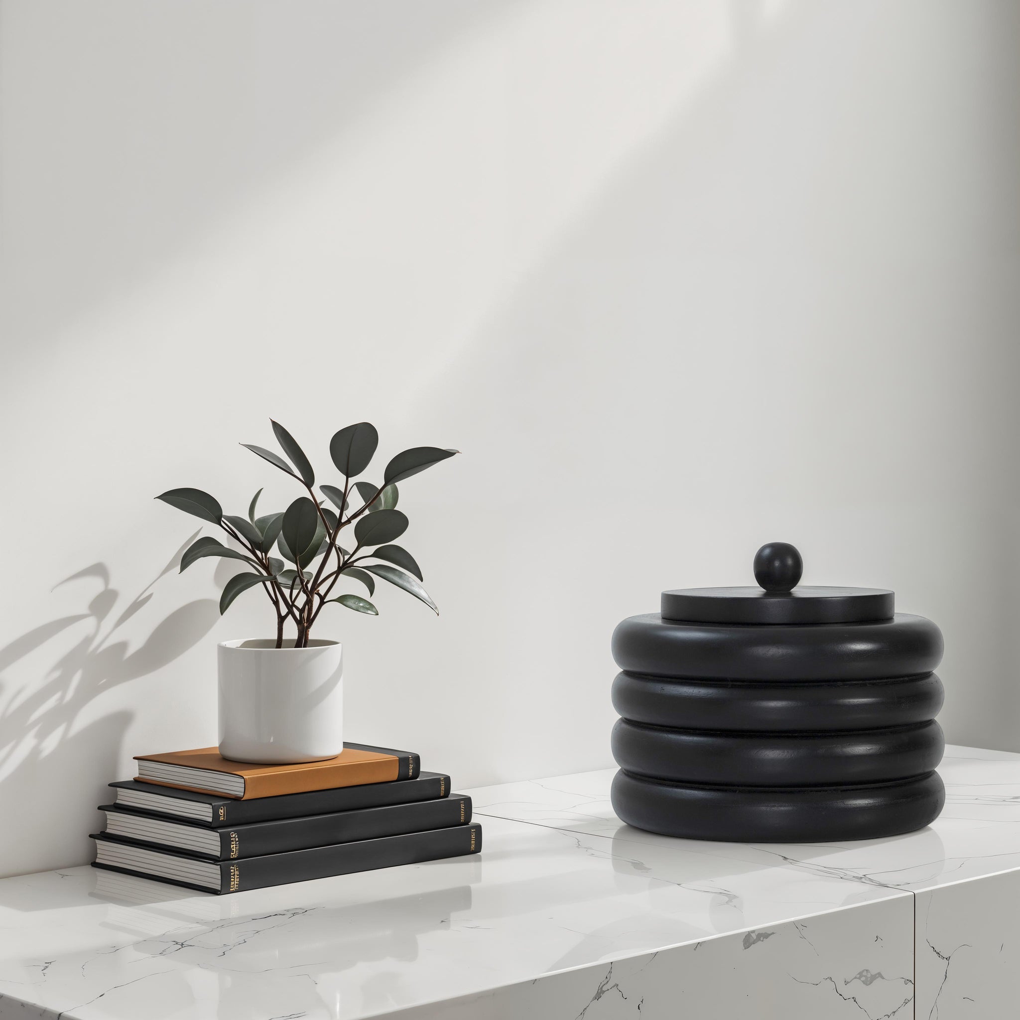 Cipher bookends by Renwil on a marble table with books and a plant.