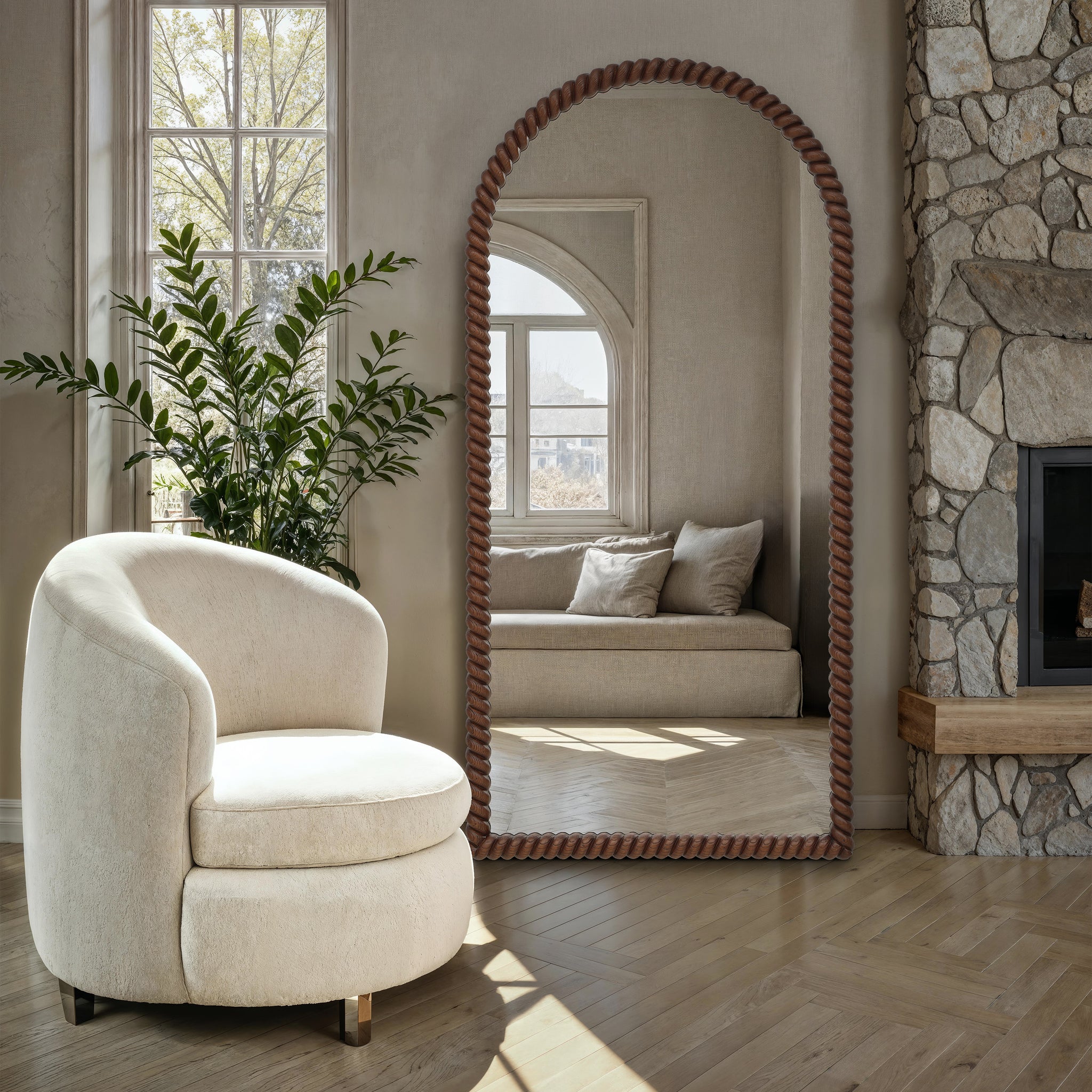 Madiwell mirror with a twisted rope frame, placed beside a cozy chair and greenery.