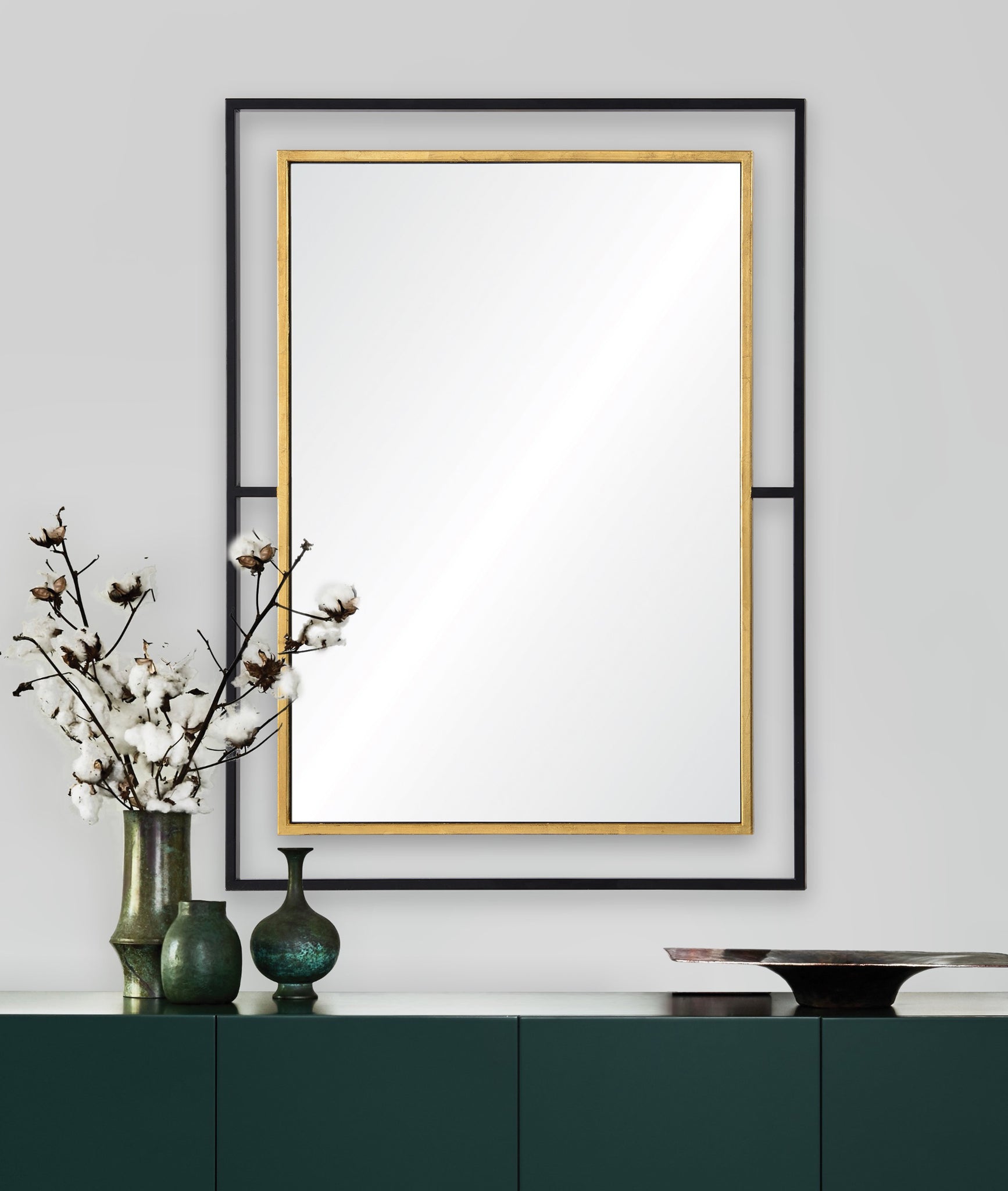 Gray Wall Mirror with a gold trim and black frame, displayed above a green cabinet with decorative vases and cotton branches.