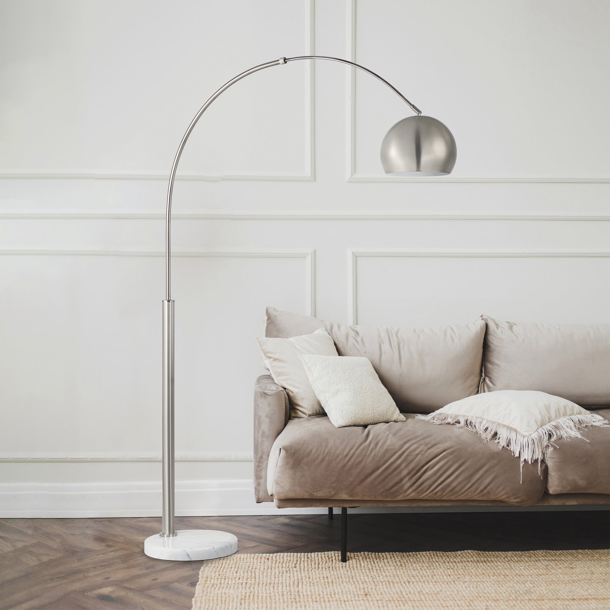 Aglow floor lamp positioned next to a cozy sofa in a stylish living room.