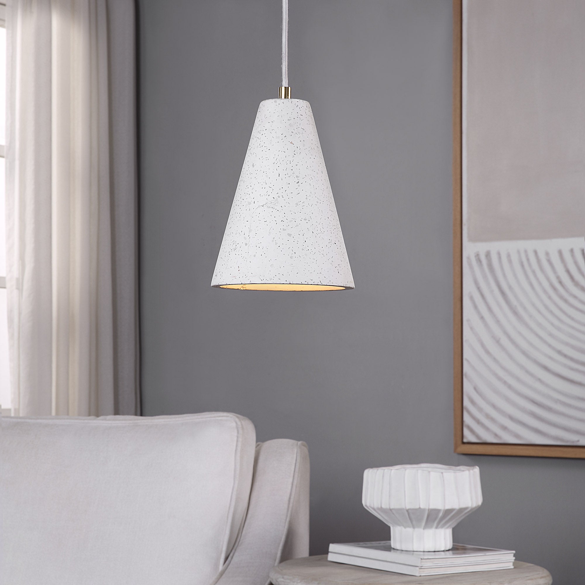 Paula ceiling light fixture in white concrete, cone shape, hanging in a modern living room setting.