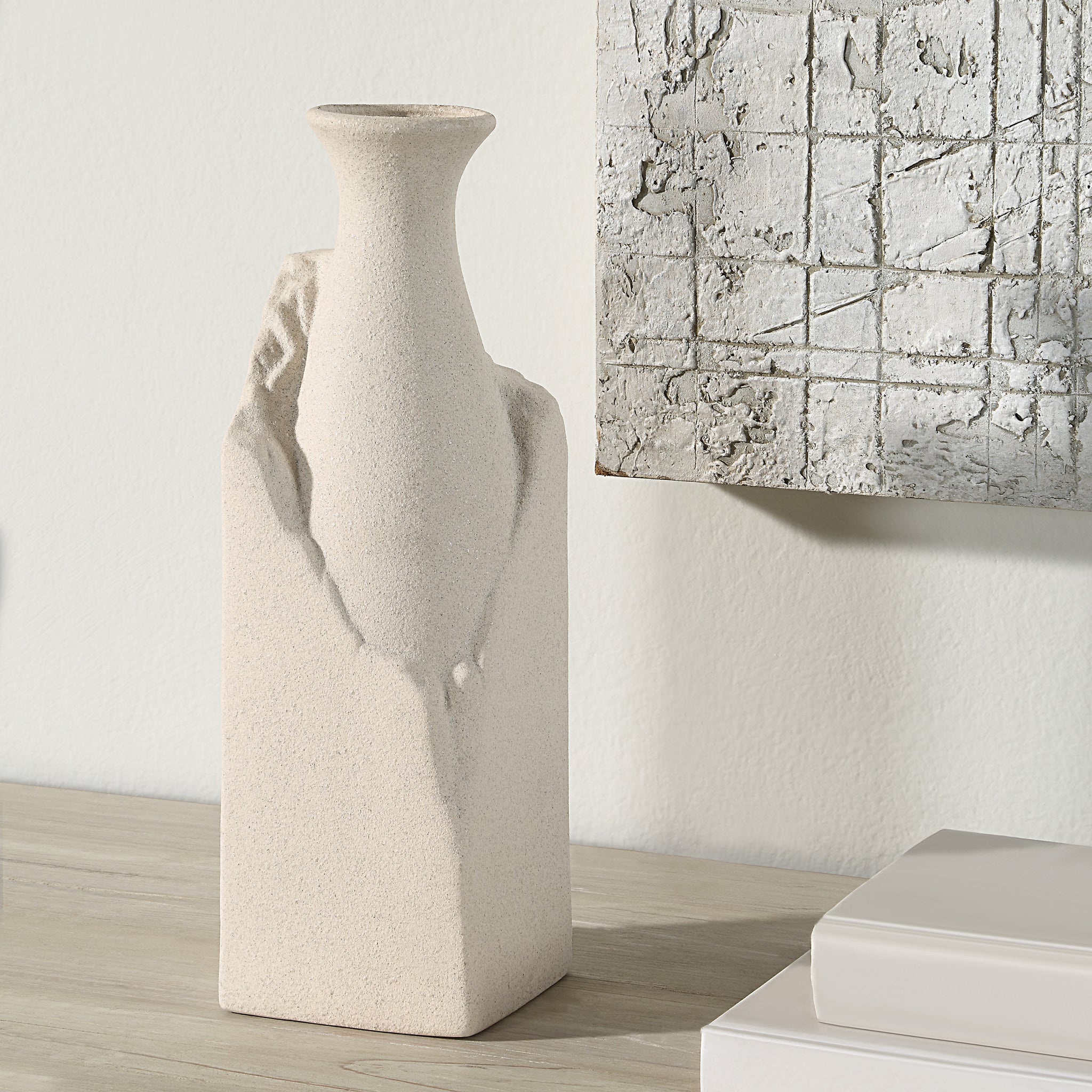 Adonia Vase by Renwil displayed on a table next to a textured wall art piece