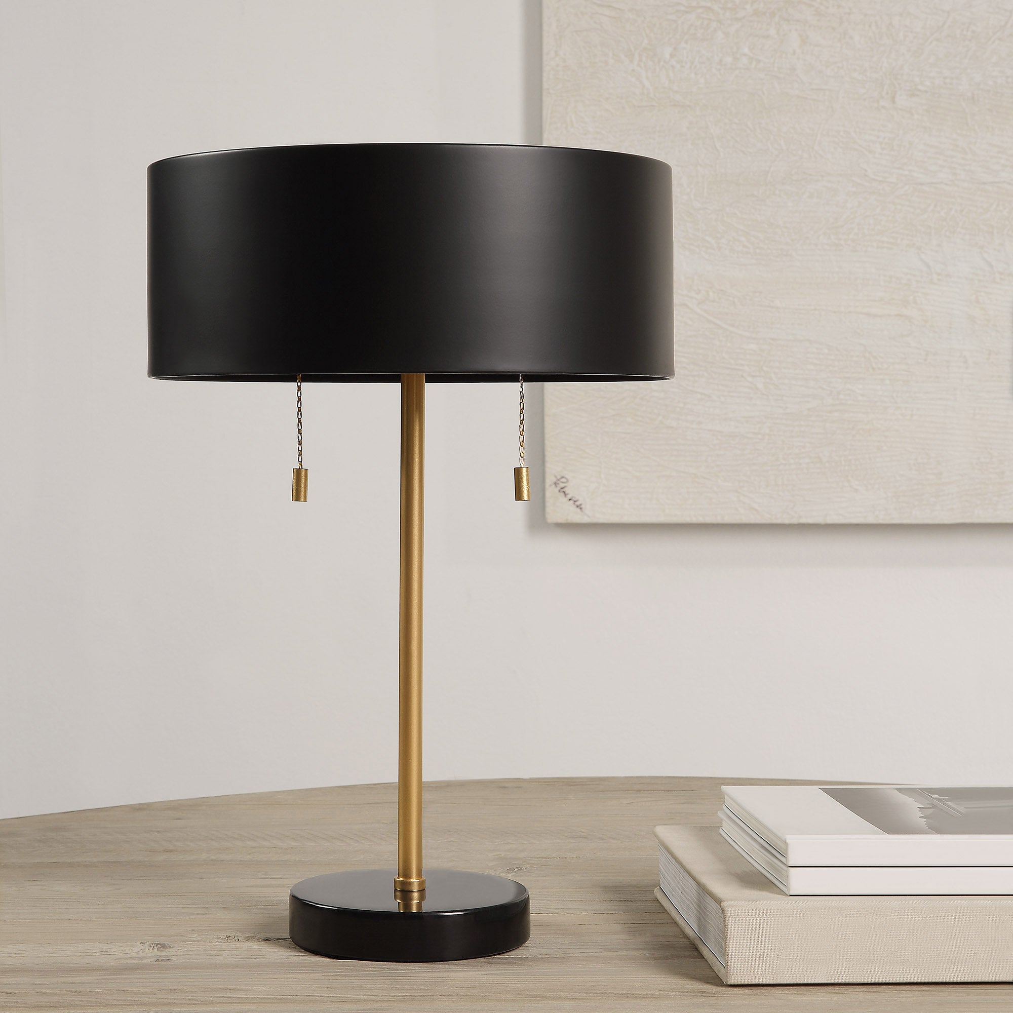 Gillian Table Lamp on a wooden table, with books beside it and a neutral background.