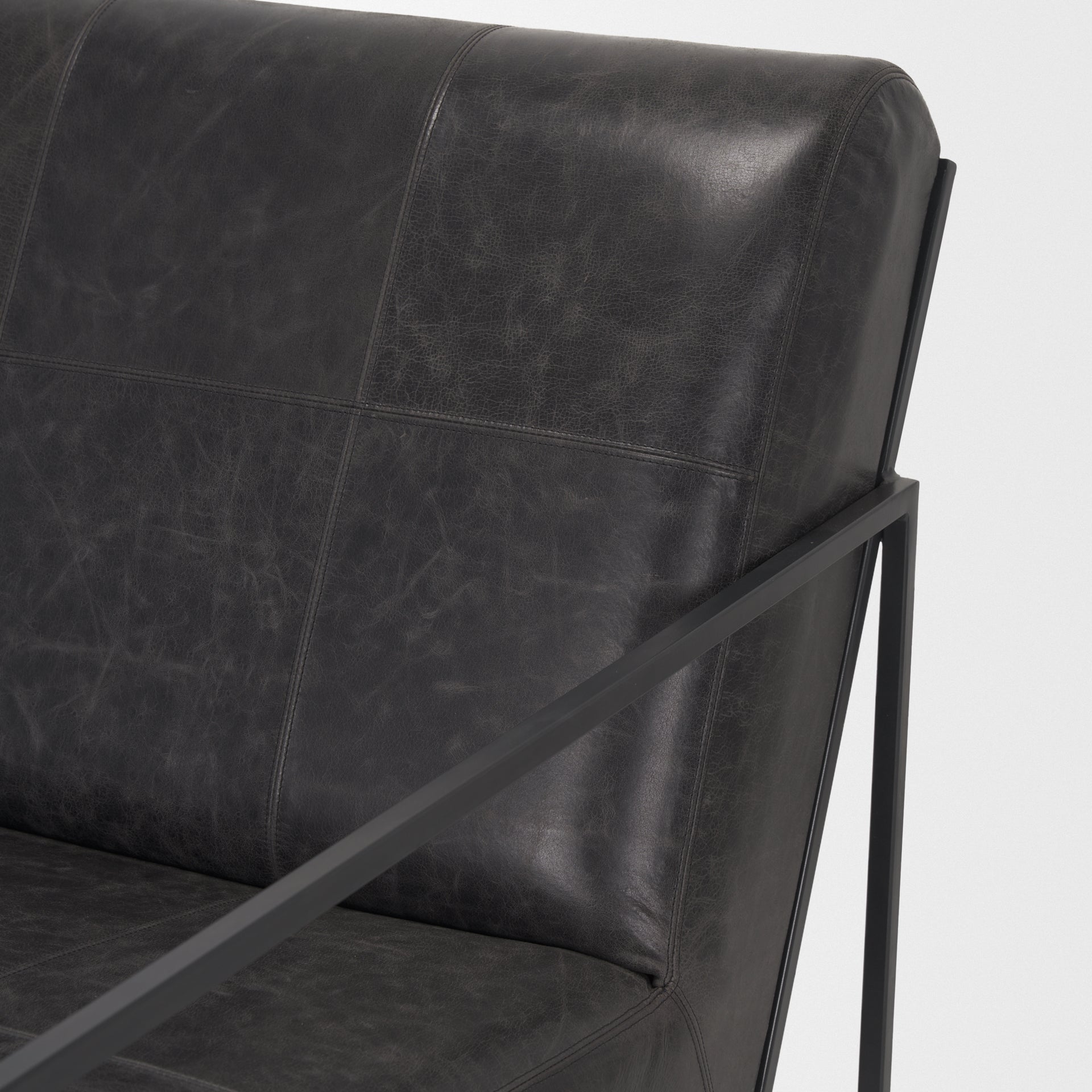 Stratton Gunmetal w/ Genuine Aged Black Leather Upholstered Accent Chair shown from a different angle to reveal its silhouette.