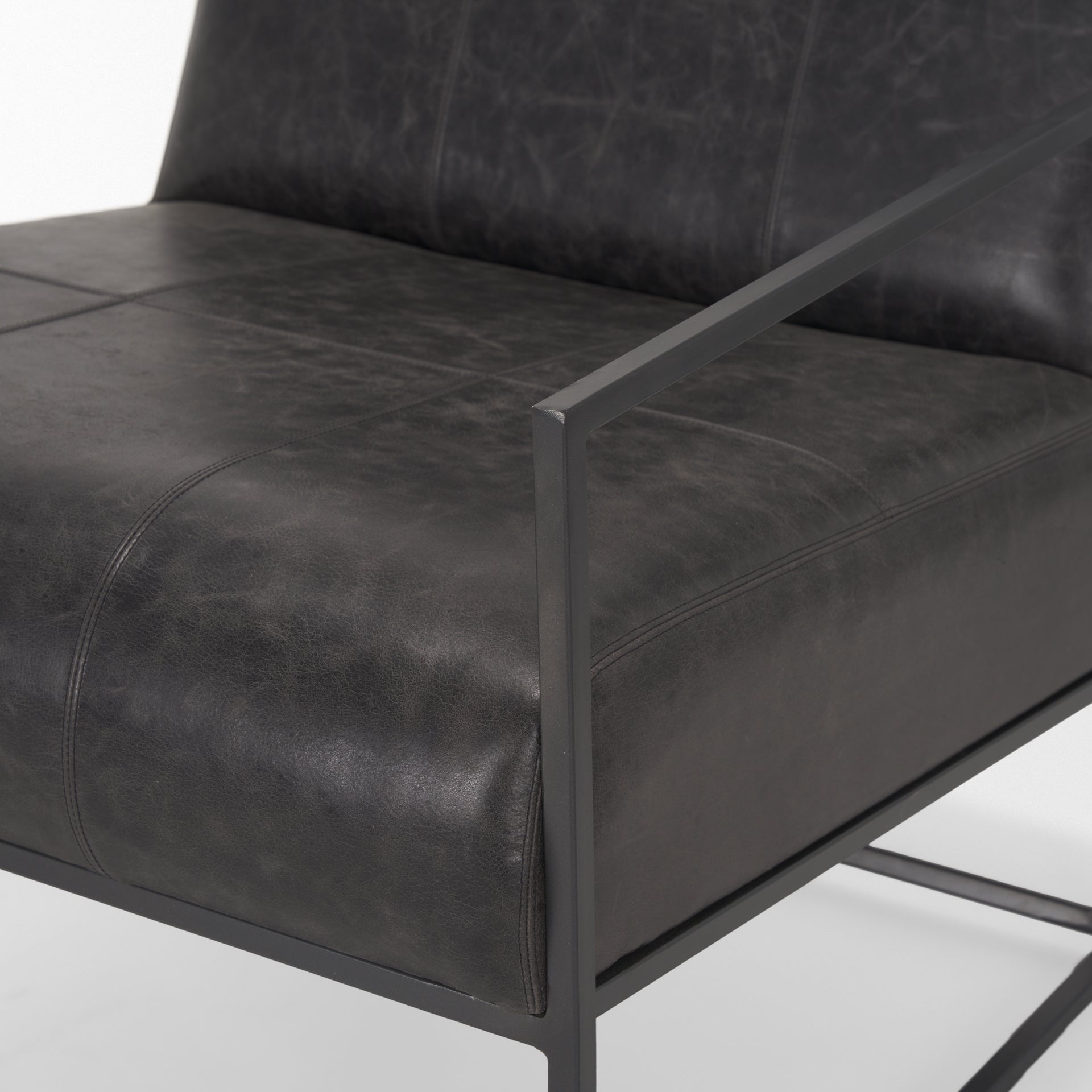 Stratton Gunmetal w/ Genuine Aged Black Leather Upholstered Accent Chair viewed from the side.