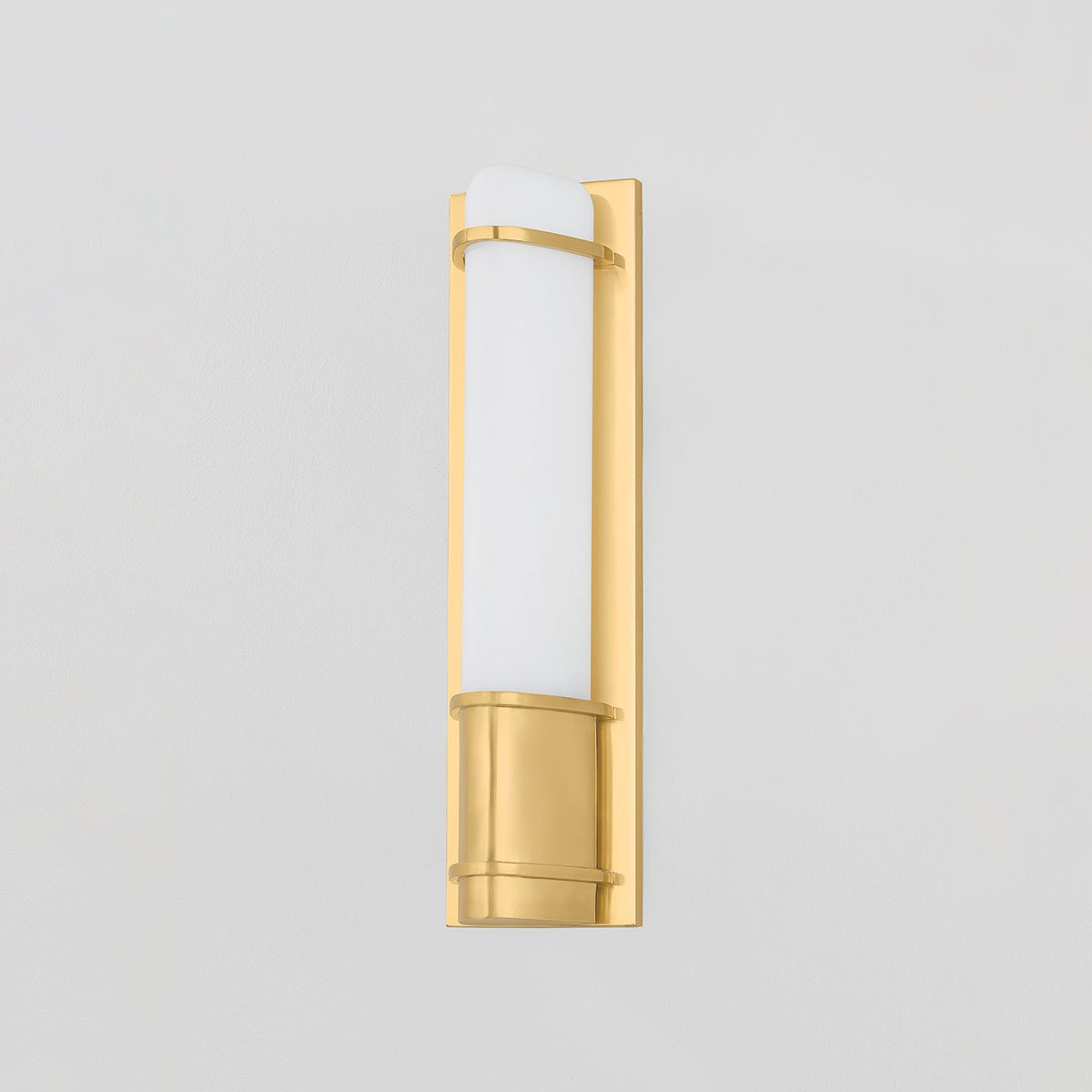 Tottenville Wall Sconce 4.25" x 16.25" in aged brass shown from the front to reveal the arm curve and shade silhouette.