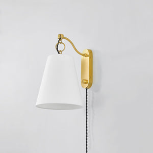 Joan Plug-In Sconce in aged brass shown from the front to reveal the arm profile and shade silhouette.