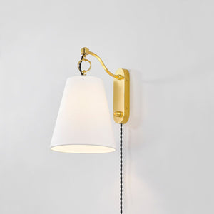 Close-up of the Joan Plug-In Sconce in aged brass showing the arm profile and shade silhouette.