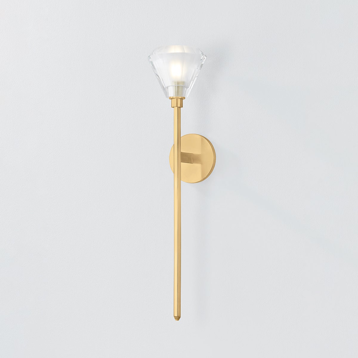 Close-up of the Maspeth Wall Sconce in aged brass showing the arm curve and shade silhouette.