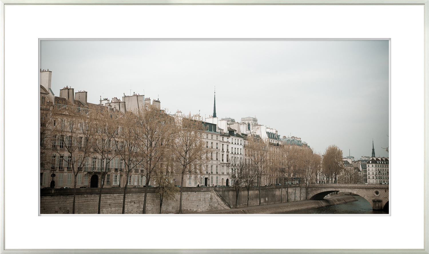 Parisian – Waters Edge wall art featuring a serene view of Parisian buildings along the river.