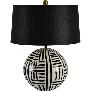 Milka table lamp showcasing a round ceramic base with black stripes and a black linen shade, viewed from the front.