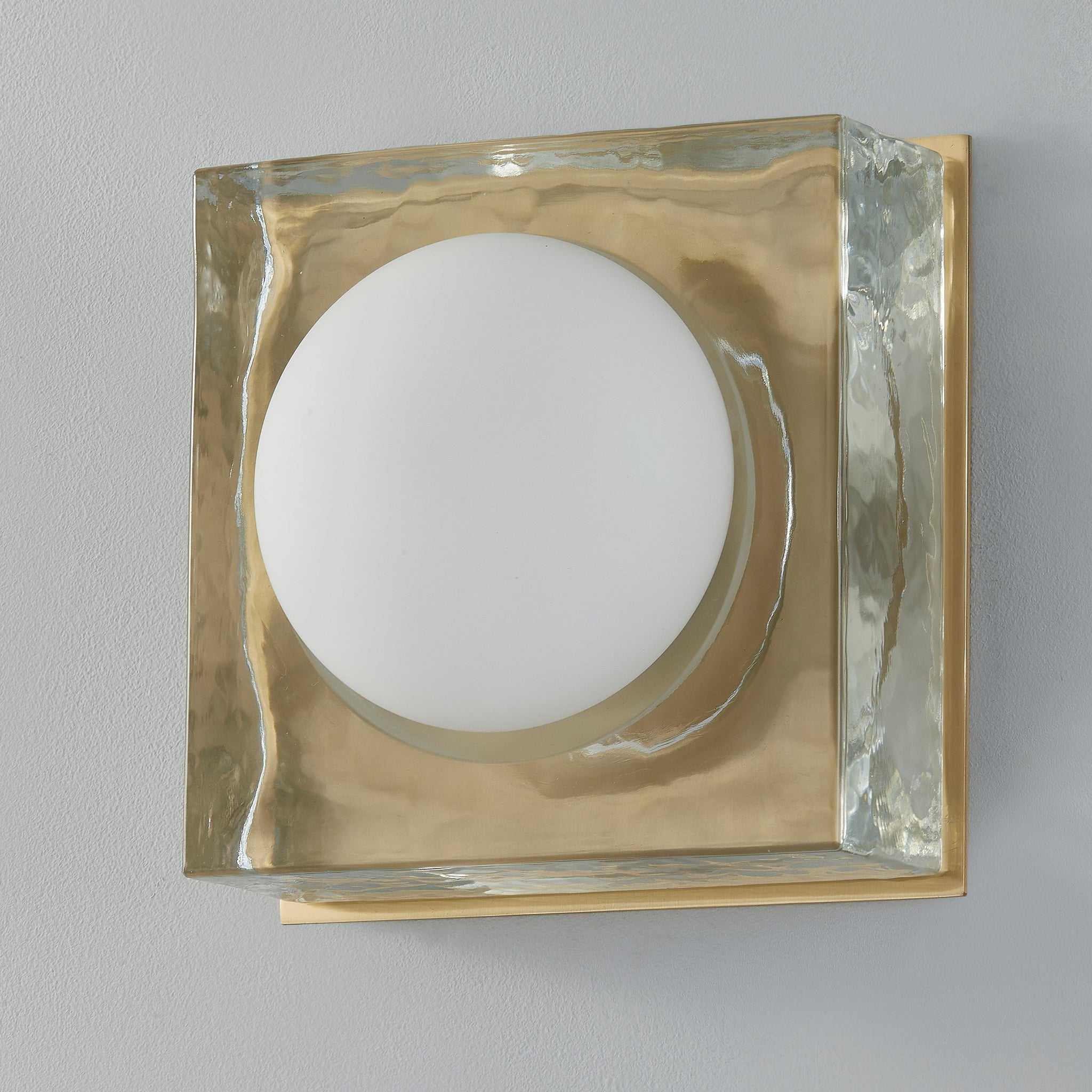 Mackay Wall Sconce 7.75" x 7.75" in aged brass shown from the front to reveal the arm curve and shade silhouette.