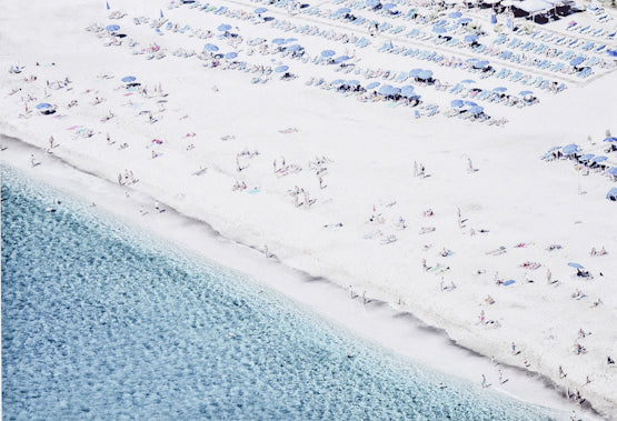 Aerial Beach View # 2 featuring a sandy beach with umbrellas and sunbathers, clear turquoise water, and a vibrant atmosphere.