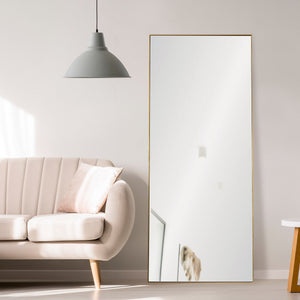 Crosland mirror in a modern living room, featuring a gold frame beside a light-colored sofa.
