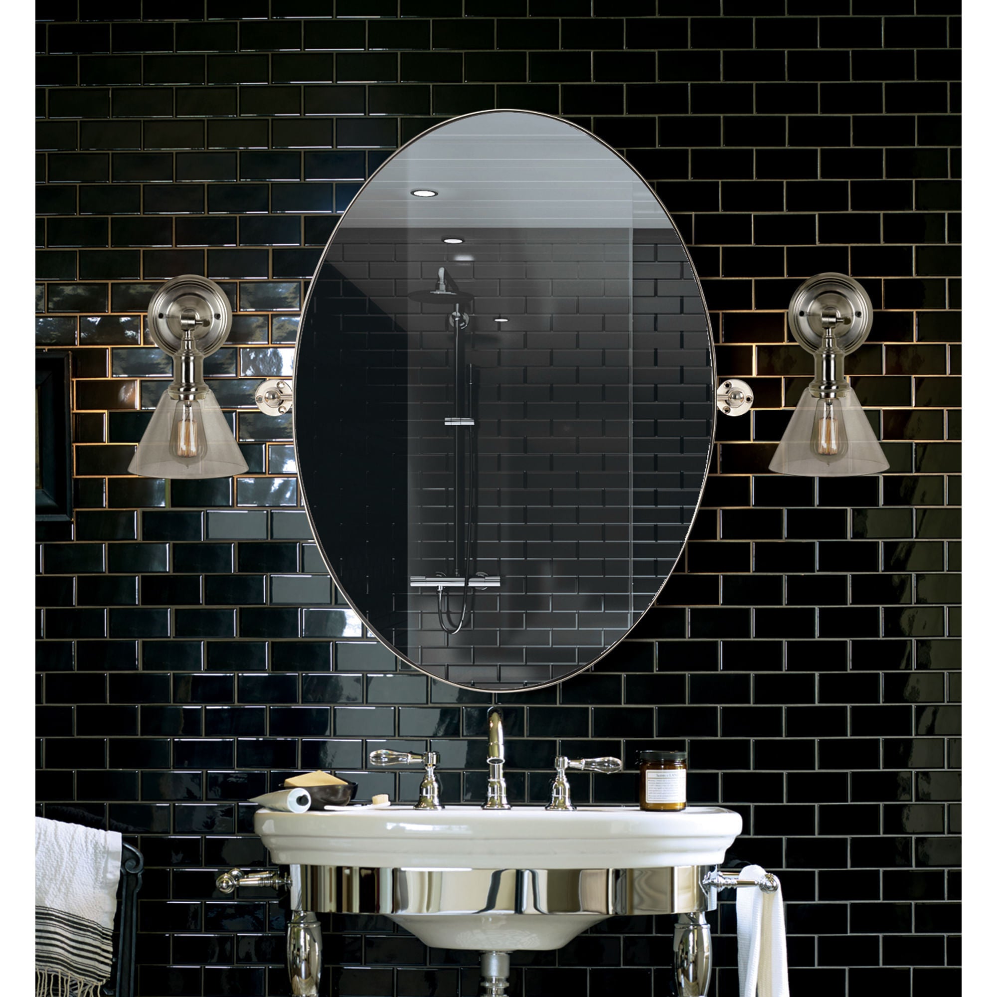 Azalea mirror by Renwil in a bathroom setting, surrounded by black tile and stylish lighting