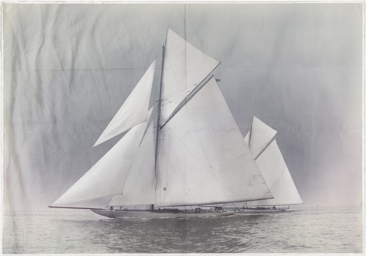 Indigo Stained – Yachts Constitution & Columbia, featuring a vintage sailboat with large white sails on calm waters.