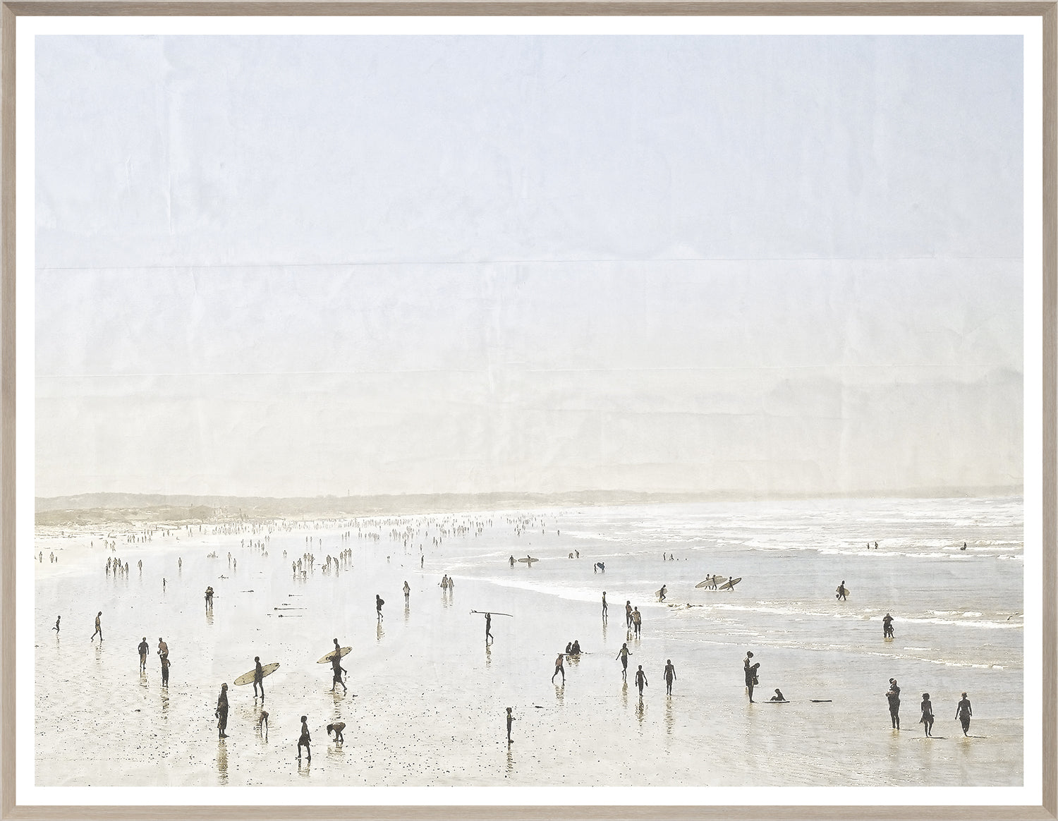 Idyllic Surf wall art depicting a lively beach scene with surfers and people, framed in light wood.