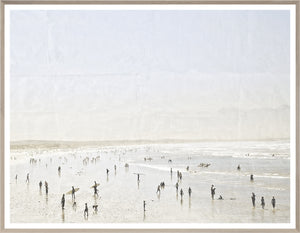 Idyllic Surf wall art depicting a lively beach scene with surfers and people, framed in light wood.