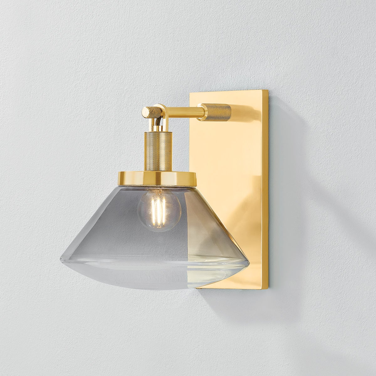 Mendon Wall Sconce in aged brass shown from the front to reveal the arm curve and shade silhouette.