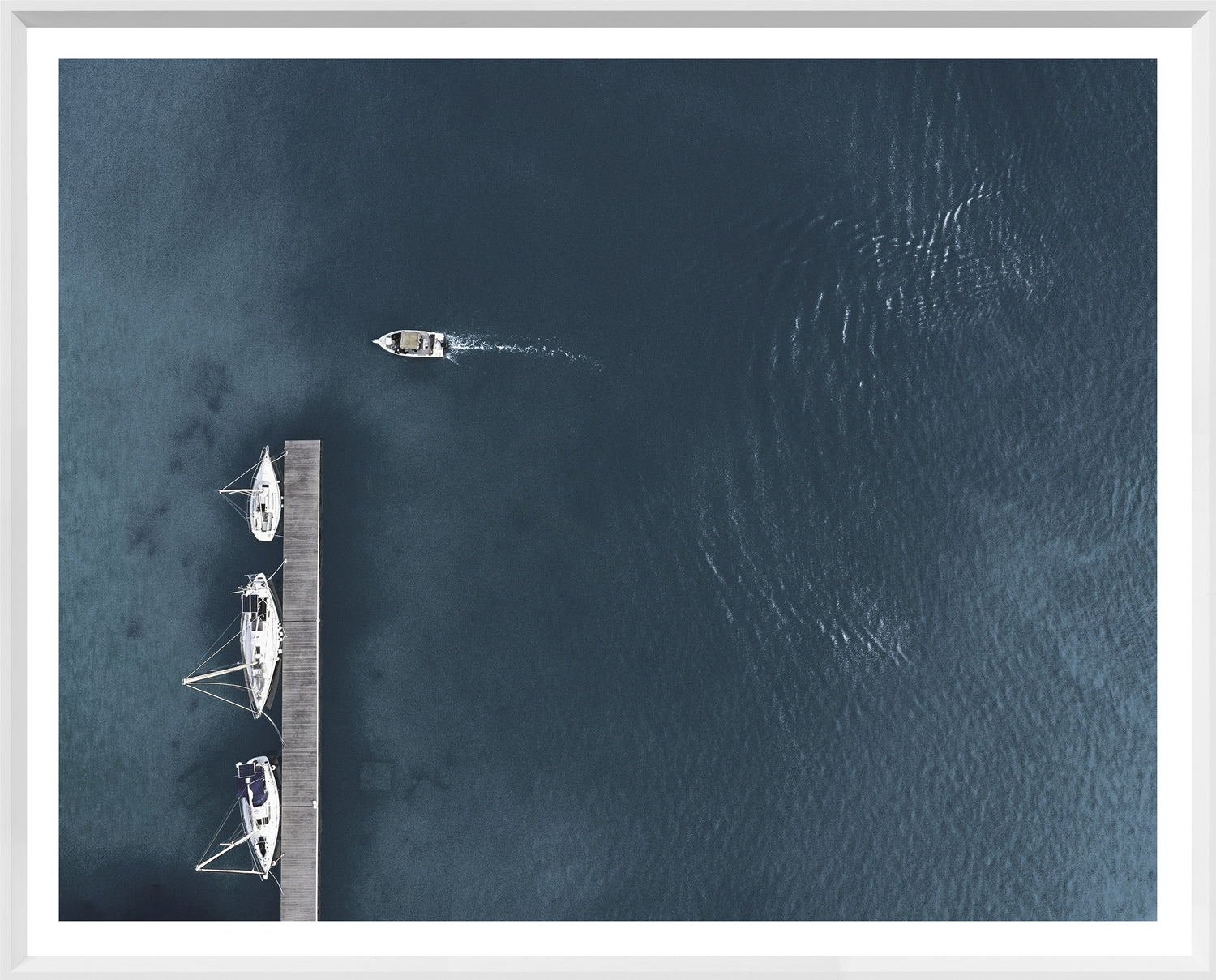 Three Yachts wall art featuring an aerial view of yachts at a dock and a boat on water.