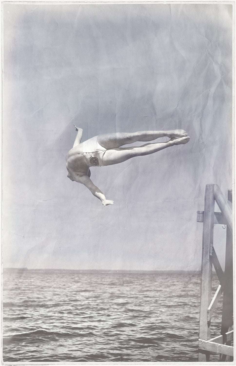 Indigo Stained – Mid Dive, a vintage-style wall art featuring a diver mid-air above water, in a faded blue and gray color palette.