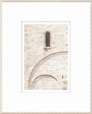 Masonry wall art featuring a stone wall with a window and arch details in light tones.